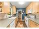 Galley kitchen featuring wood cabinets, contrasting backsplash, and stainless steel appliances at 2511 Oak Ave, Tucker, GA 30084