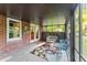 Relaxing screened porch with brick wall, ceiling fan and wicker furniture overlooking the yard at 2511 Oak Ave, Tucker, GA 30084