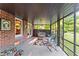 Relaxing screened porch with brick wall, ceiling fan and wicker furniture overlooking the yard at 2511 Oak Ave, Tucker, GA 30084