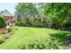 Green grass and manicured backyard with a wooden bench and mature trees at 5199 Beech Forest Sw Dr, Lilburn, GA 30047
