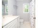 Bright bathroom features a white vanity and modern fixtures, with a shower featuring a patterned curtain at 5199 Beech Forest Sw Dr, Lilburn, GA 30047