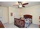 Cozy bedroom features neutral carpeting, a ceiling fan, and traditional wood furniture at 5199 Beech Forest Sw Dr, Lilburn, GA 30047