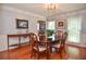 Sunlit dining area featuring hardwood floors, decorative art, and a traditional wood dining set at 5199 Beech Forest Sw Dr, Lilburn, GA 30047