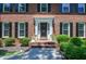 Inviting front entrance featuring a classic brick facade, black shutters, and manicured greenery at 5199 Beech Forest Sw Dr, Lilburn, GA 30047