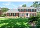 Charming two-story brick home with manicured lawn, lush landscaping, and classic black shutters at 5199 Beech Forest Sw Dr, Lilburn, GA 30047