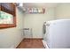 Functional laundry room featuring modern washer and dryer, storage shelves, and a convenient folding rack at 5199 Beech Forest Sw Dr, Lilburn, GA 30047