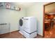 Well-organized laundry area with modern washer and dryer, overhead shelving, adjacent to the kitchen area at 5199 Beech Forest Sw Dr, Lilburn, GA 30047