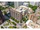 An aerial view of the condo building surrounded by city streets, trees, and other buildings, emphasizing its location at 620 Peachtree Ne St # 1716, Atlanta, GA 30308
