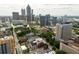 Elevated view of a city skyline featuring various high-rise buildings and landmarks amid lush greenery at 620 Peachtree Ne St # 1716, Atlanta, GA 30308