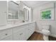 Bright bathroom with double vanity, framed mirrors, modern fixtures, toilet, and a window at 3306 Emory Dr, Marietta, GA 30062
