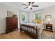 Bright bedroom features a queen-sized bed, hardwood floors, and natural light from windows with green views at 3306 Emory Dr, Marietta, GA 30062