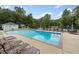 A community pool with lounge chairs and tables surrounded by lush trees on a sunny day at 3306 Emory Dr, Marietta, GA 30062