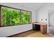 Bedroom with built in desk and drawers, large windows overlooking mature trees, and light walls at 5800 Mitchell Rd, Atlanta, GA 30328