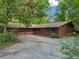 Spacious home featuring an attached garage and concrete driveway, surrounded by lush greenery at 5800 Mitchell Rd, Atlanta, GA 30328