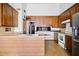 Kitchen featuring wood cabinets, stainless steel appliances, lots of storage, and open access to the living room at 5800 Mitchell Rd, Atlanta, GA 30328