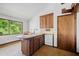 Kitchen with a large window overlooking mature trees, wood cabinets, stainless steel appliances, and an island at 5800 Mitchell Rd, Atlanta, GA 30328