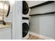 Modern bathroom featuring wood-look tile, stacked washer and dryer and floating shelves at 6851 Roswell Rd # K-23, Atlanta, GA 30328