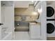 Bathroom featuring a shower/tub, vanity, and stacked washer/dryer and modern fixtures and wood accent wall at 6851 Roswell Rd # K-23, Atlanta, GA 30328
