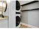 Contemporary bathroom featuring modern stacked washer/dryer with floating wood shelves at 6851 Roswell Rd # K-23, Atlanta, GA 30328