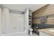Updated bathroom features a tiled shower, wood accent wall, and modern sink with grey walls and light-colored flooring at 6851 Roswell Rd # K-23, Atlanta, GA 30328