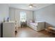 Bright bedroom with light blue walls, ceiling fan, and large window with natural sunlight at 6851 Roswell Rd # K-23, Atlanta, GA 30328