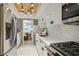 Modern kitchen with white cabinets, marble backsplash, stainless steel appliances, and stylish lighting fixture at 6851 Roswell Rd # K-23, Atlanta, GA 30328