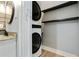 Laundry area featuring a stackable washer and dryer, and shelves, beside the bathroom at 6851 Roswell Rd # K-23, Atlanta, GA 30328