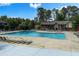 Community swimming pool surrounded by chairs and lush trees with an adjacent apartment complex at 6851 Roswell Rd # K-23, Atlanta, GA 30328
