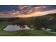 Scenic sunset aerial view of a pond, golf course, and mountain views at 237 Laurel Vista Dr, Canton, GA 30114