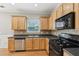 Kitchen featuring hardwood floors, stainless dishwasher, and black gas range at 5221 Sherwood Way, Cumming, GA 30040