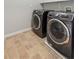Convenient laundry room featuring modern washer and dryer units, with tiled flooring at 5221 Sherwood Way, Cumming, GA 30040