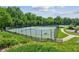 Community tennis courts surrounded by fences and lush greenery offer an active lifestyle at 5221 Sherwood Way, Cumming, GA 30040