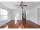 A bedroom featuring hardwood floors, white walls, windows, a ceiling fan, and a hallway at 1102 Madison Ln # 1102, Smyrna, GA 30080