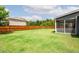 Backyard featuring lush green grass, a privacy fence, and a screened porch for outdoor enjoyment at 1809 Hanwoo Ln, Powder Springs, GA 30127