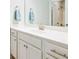 Modern bathroom vanity with white cabinets, brushed nickel hardware, and a framed mirror at 1809 Hanwoo Ln, Powder Springs, GA 30127