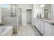 Modern bathroom featuring a glass-enclosed shower, soaking tub, and stylish vanity with granite countertops at 1809 Hanwoo Ln, Powder Springs, GA 30127