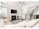 Bright living room with a fireplace, ceiling fan, staircase, and comfortable seating at 1809 Hanwoo Ln, Powder Springs, GA 30127