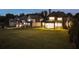 Night view of a sprawling green backyard and the home's exterior, with multiple windows lit at 4253 Biltmore Pl, Marietta, GA 30062