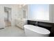 Bright bathroom featuring a soaking tub, large window, and white marble floors at 4253 Biltmore Pl, Marietta, GA 30062