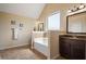 Bright bathroom with a bathtub, vanity, and tile flooring at 5805 Fielding Ct, Cumming, GA 30041