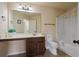 Well-lit bathroom with large mirror, vanity, toilet and shower-tub combo at 5805 Fielding Ct, Cumming, GA 30041