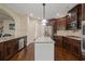 Open concept kitchen with dark wood cabinetry, granite counters, stainless steel appliances and island at 5805 Fielding Ct, Cumming, GA 30041