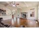 Open-concept living room with a stone fireplace, hardwood floors, and connection to the kitchen at 5805 Fielding Ct, Cumming, GA 30041