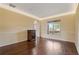 Large room with hardwood floors, trim and decorative moulding, and a sunny window view at 5805 Fielding Ct, Cumming, GA 30041