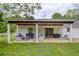 Spacious backyard featuring a covered patio, modern seating, and lush green grass at 7925 Silversmith Dr, Cumming, GA 30028