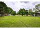 Spacious backyard featuring a lush green lawn, mature trees, shed, and a covered patio for outdoor enjoyment at 7925 Silversmith Dr, Cumming, GA 30028