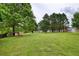 Expansive backyard featuring a playground, mature trees, and ample space for outdoor enjoyment at 7925 Silversmith Dr, Cumming, GA 30028