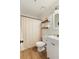 Functional bathroom featuring wood-look floors, shower curtain, and floating shelves at 7925 Silversmith Dr, Cumming, GA 30028