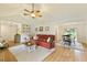 Open-concept living room with a fireplace, ceiling fan, and access to the dining area at 7925 Silversmith Dr, Cumming, GA 30028