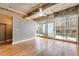 Open concept living room with hardwood floors, industrial ceilings, and a wall of windows at 890 Memorial Se Dr # 105, Atlanta, GA 30316